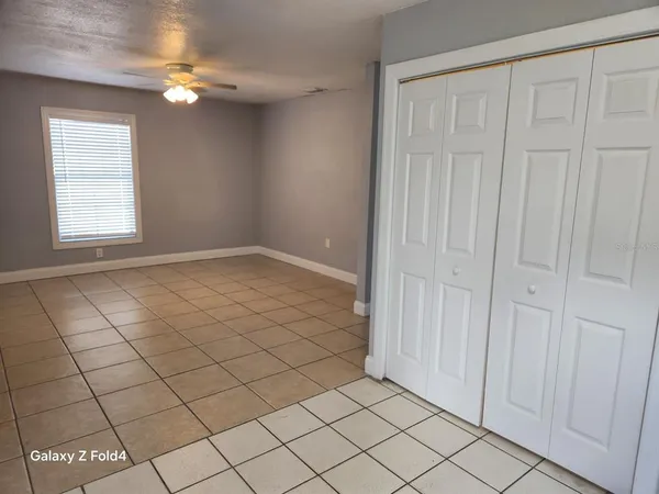 an empty room with windows and fan