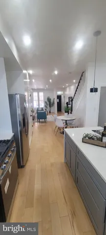 a kitchen with kitchen island a stove a chimney a sink and a refrigerator