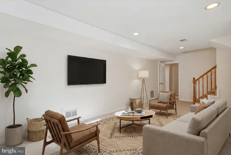 a living room with furniture and a book shelf