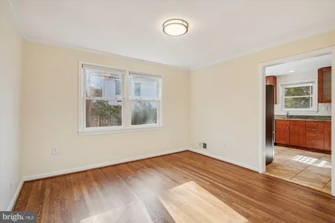an empty room with wooden floor fireplace and windows