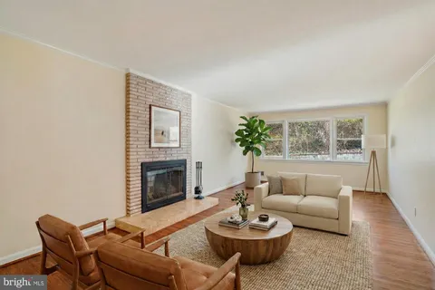 a living room with furniture a fireplace and a large window