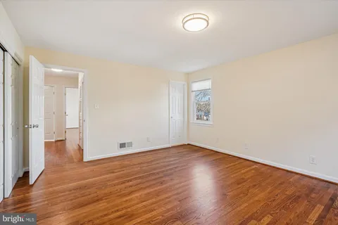 a view of room with wooden floor and white walls