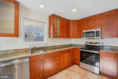 a kitchen with stainless steel appliances granite countertop a sink stove and microwave