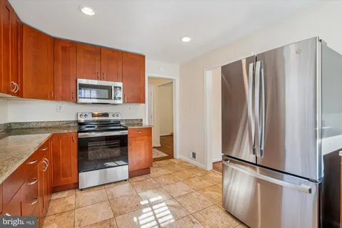 a kitchen with stainless steel appliances granite countertop a refrigerator stove and microwave