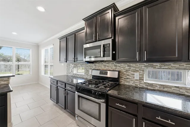 a kitchen with stainless steel appliances granite countertop a sink stove and microwave