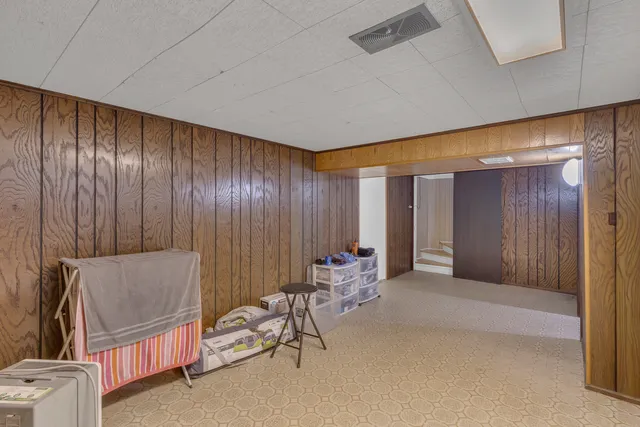 a bedroom with a bed and a wooden floor