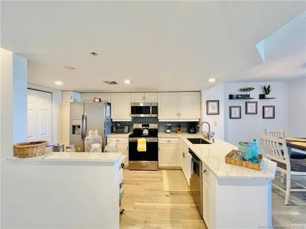 a kitchen with a refrigerator and a stove top oven