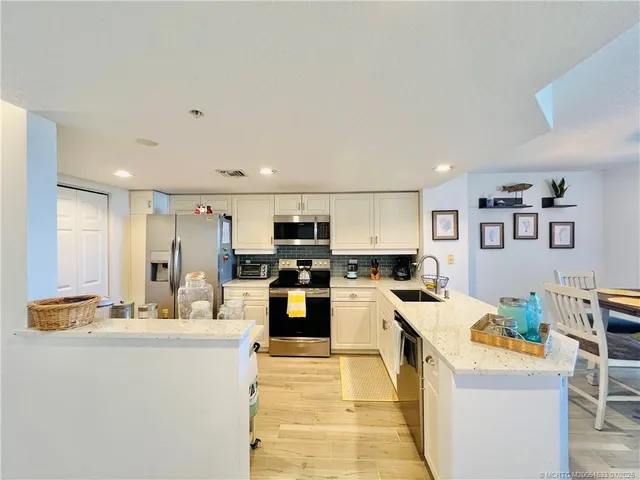 a kitchen with a refrigerator and a stove top oven