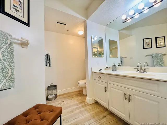 a spacious bathroom with a granite countertop sink and a mirror