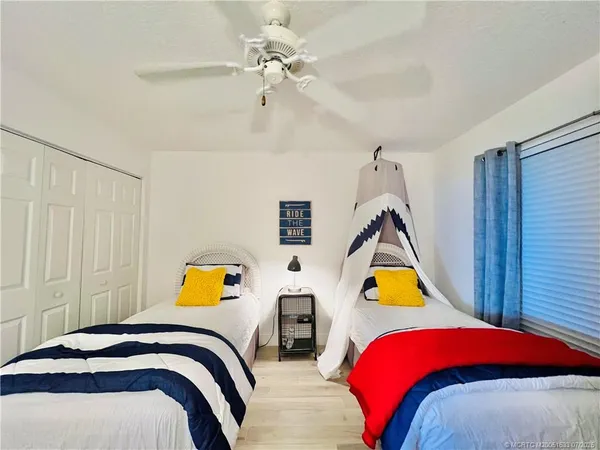 a view of a multi story residential apartment building with a yard and large trees