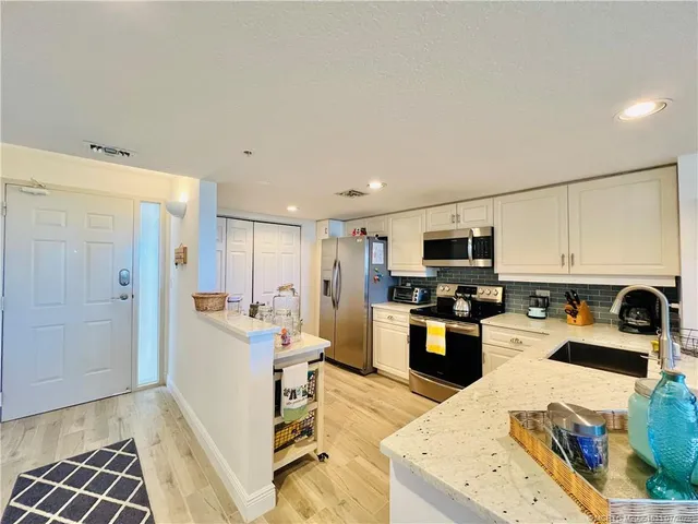 a kitchen with stainless steel appliances granite countertop a stove a sink and a microwave