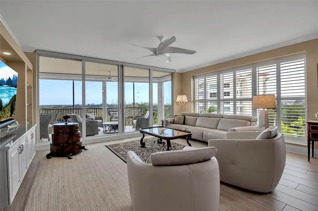 a living room with furniture and floor to ceiling windows