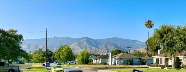a view of an house with a big yard and palm trees