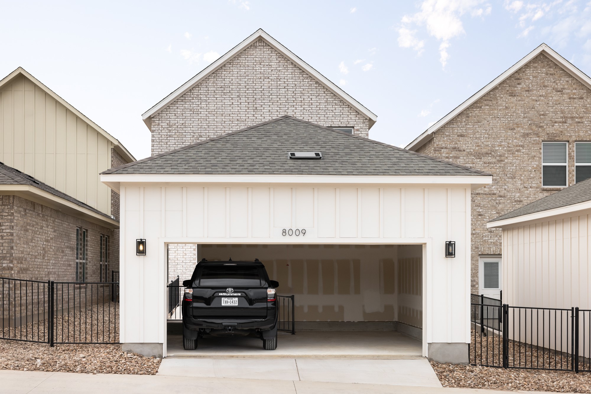 8107 Wilder Road Austin, TX 78736 - Photo 31 of 35 A detached two-car garage offers ample parking, complementing the surrounding brick and board-and-batten siding residences.