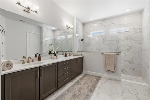 a spacious bathroom with a double vanity sink a mirror and a shower
