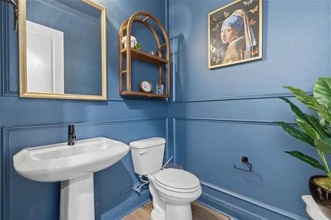 a bathroom with a toilet a sink and a mirror