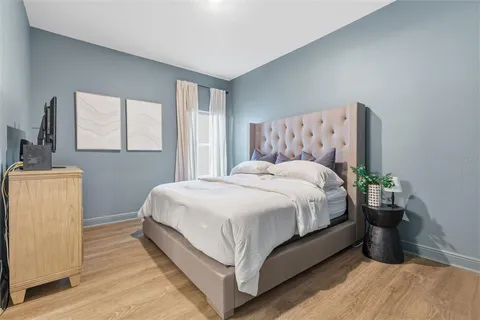 a large bed sitting in a bedroom next to a window and dresser