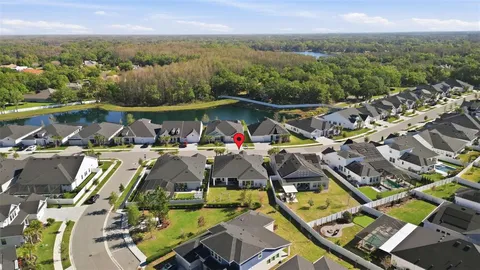 an aerial view of a house with swimming pool and mountains