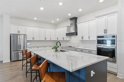a kitchen with stainless steel appliances granite countertop a table chairs sink refrigerator and microwave
