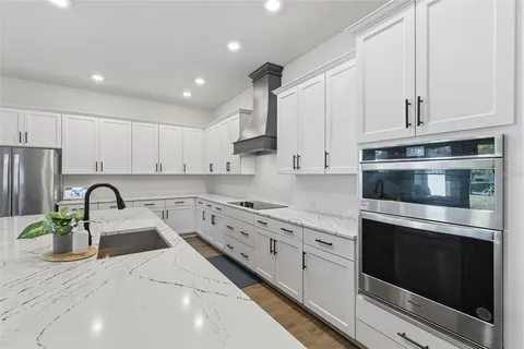 a kitchen with stainless steel appliances granite countertop a stove sink and cabinets