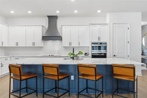 a kitchen with stainless steel appliances granite countertop a stove a sink a microwave a dining table and chairs