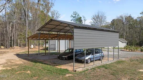 a kitchen with stainless steel appliances granite countertop a refrigerator a stove a sink a dining table and chairs with wooden floor