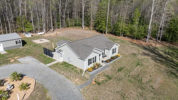 a living room with a dining table and paintings on the wall