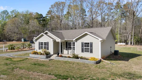 a view of a house with a yard and large tree
