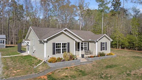 a view of a house with a yard and large trees