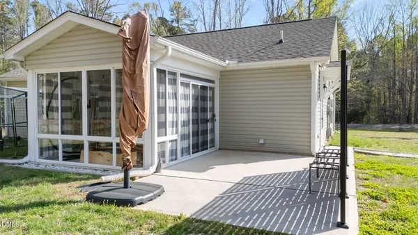 a view of a white house with a yard and sitting area