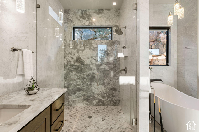 3652 South Cypress Road Hurricane, UT 84737 - Photo 63 of 81 Glass-enclosed shower with a rainfall showerhead, herringbone tile flooring, and stone wall tiling