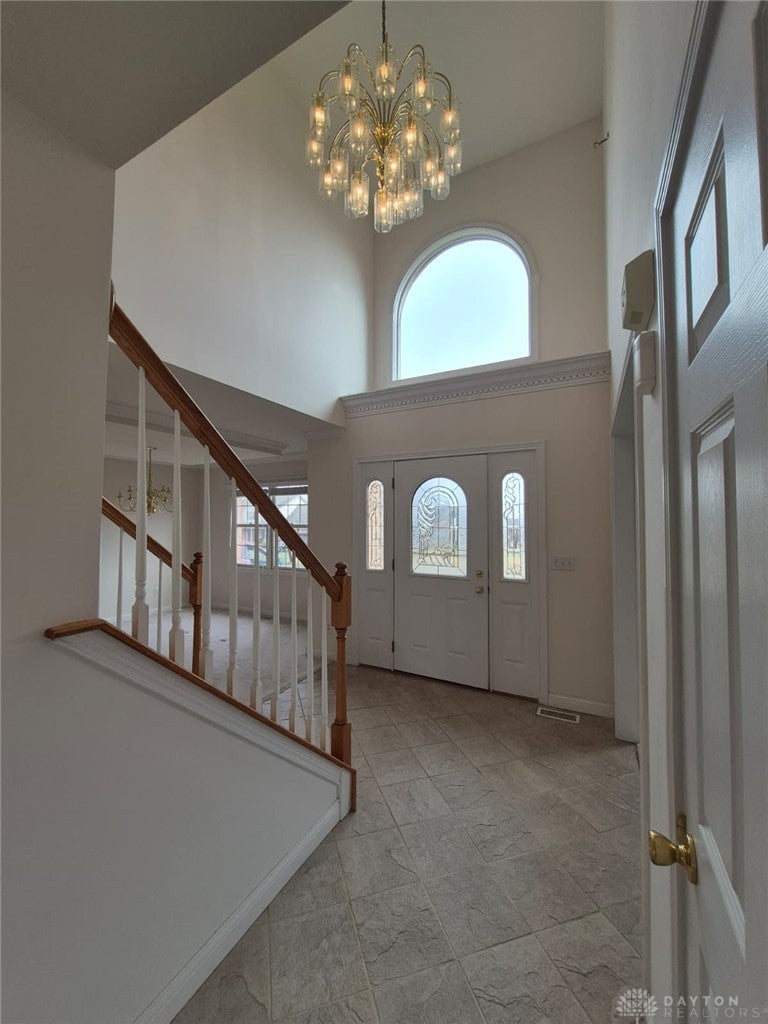 This grand foyer welcomes with a soaring ceiling and abundant natural light.