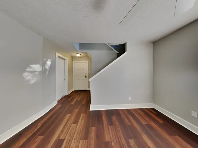 a view of empty room with wooden floor