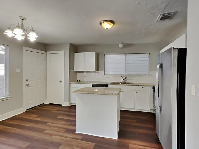 a kitchen with a refrigerator sink and cabinets