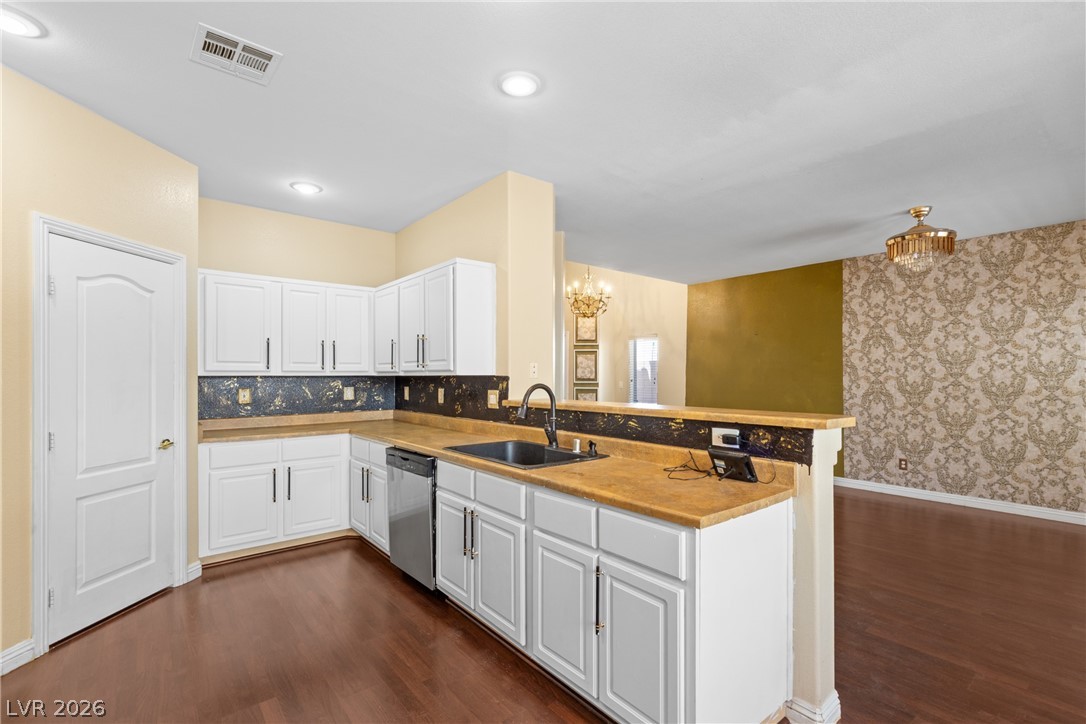 8934 Deep Ridge Court Las Vegas, NV 89178 - Photo 11 of 47 A well-appointed kitchen boasts white cabinetry, modern appliances, and rich wood flooring.