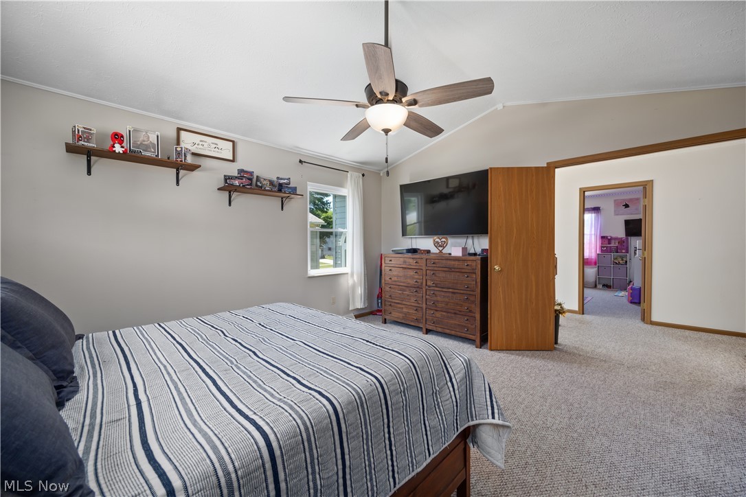684 Guilford Road Vermilion, OH 44089 - Photo 20 of 37 Bedroom featuring lofted ceiling, crown molding, carpet floors, and ceiling fan