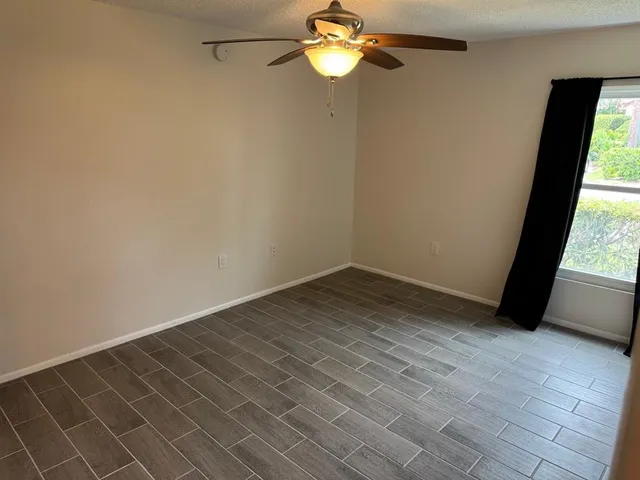 a view of a room with wooden floor and a window