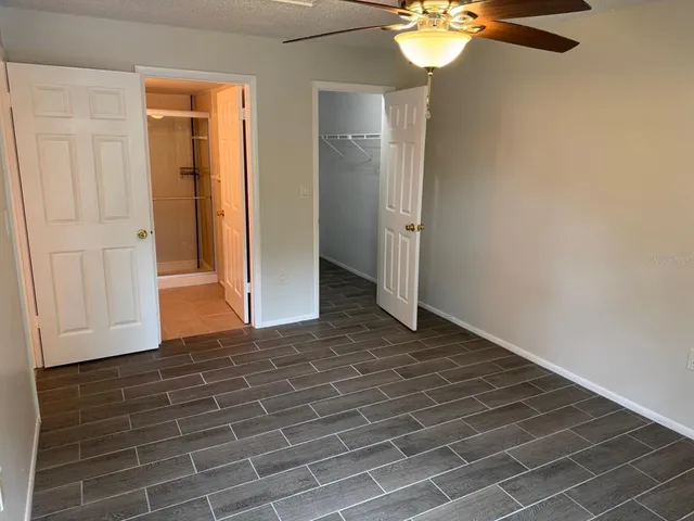 a view of an empty room with a chandelier fan
