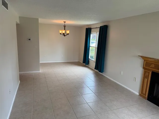 a view of a livingroom with an empty space and a fireplace