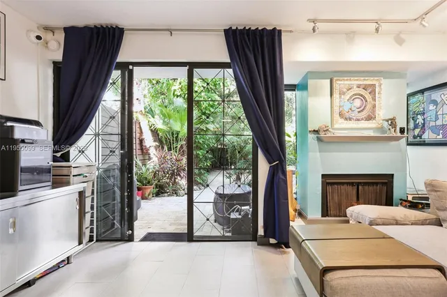 a living room with fireplace furniture and a large window