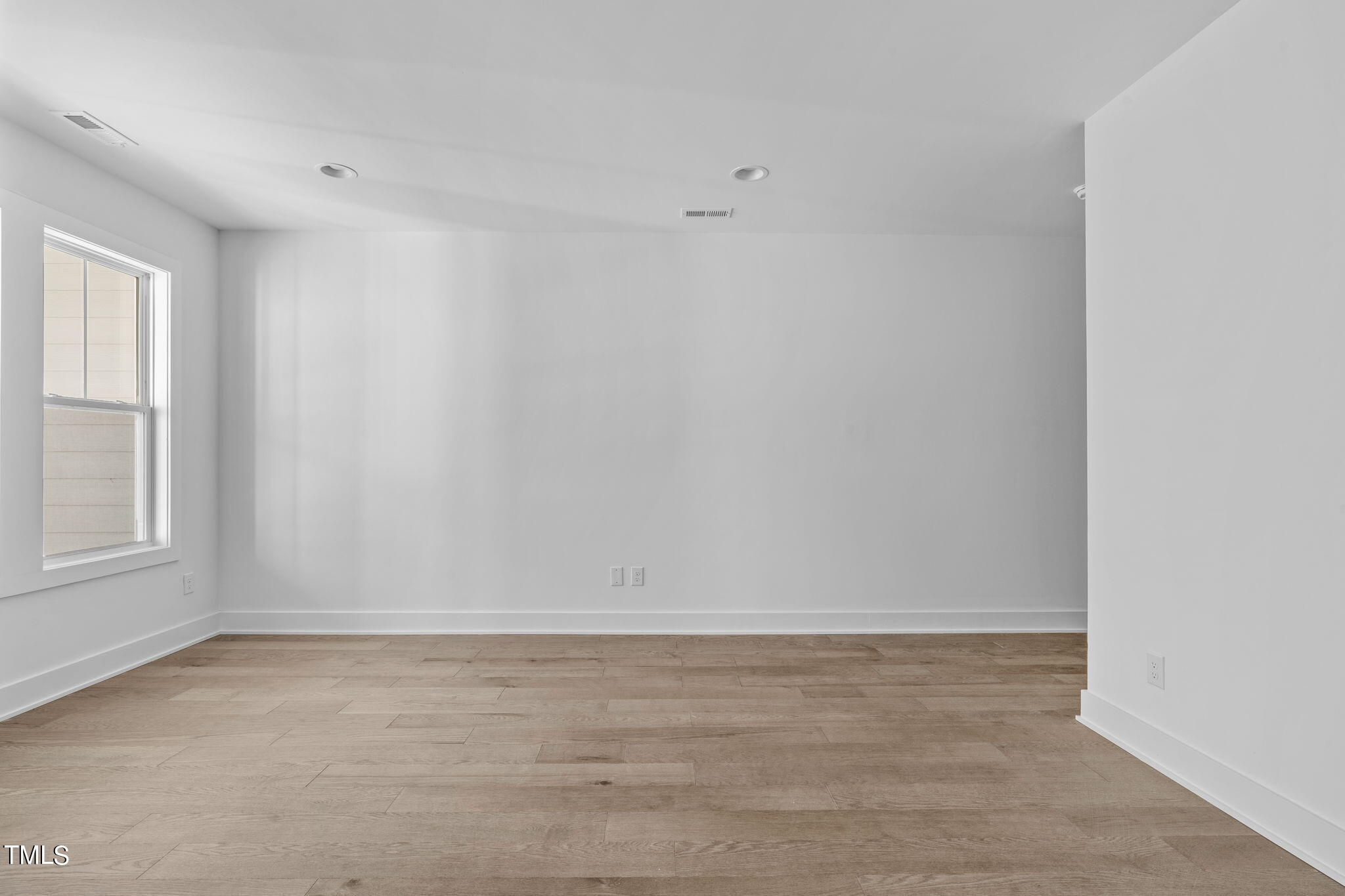 853 Athens Drive, Unit 101 Raleigh, NC 27606 - Photo 23 of 61 a view of an empty room with wooden floor and a window