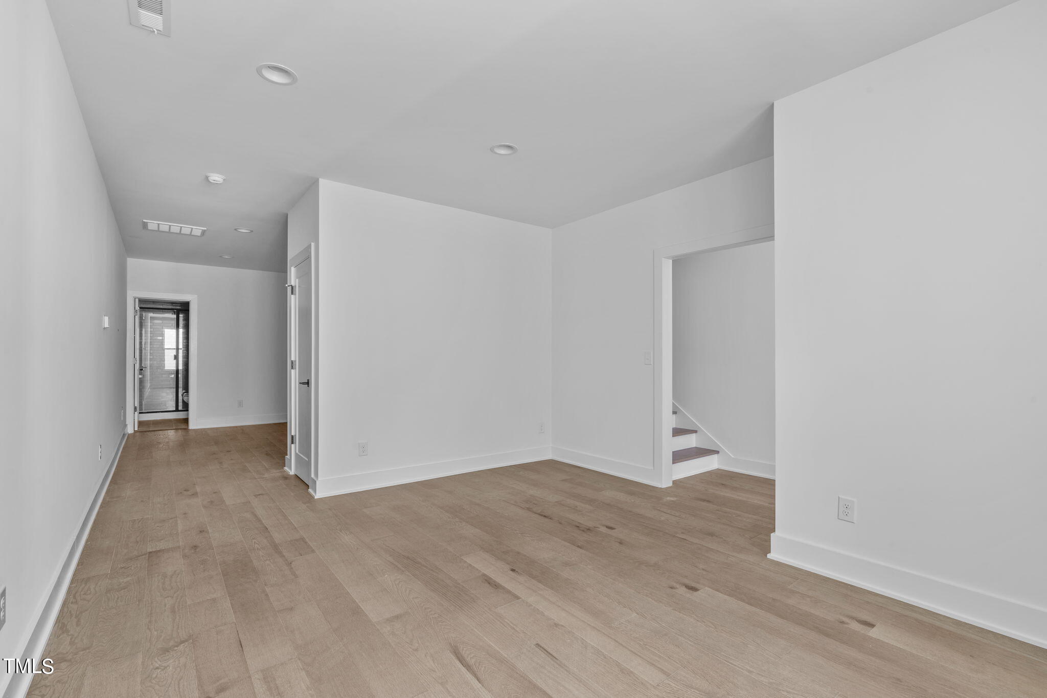 853 Athens Drive, Unit 101 Raleigh, NC 27606 - Photo 24 of 61 an empty room with wooden floor and windows