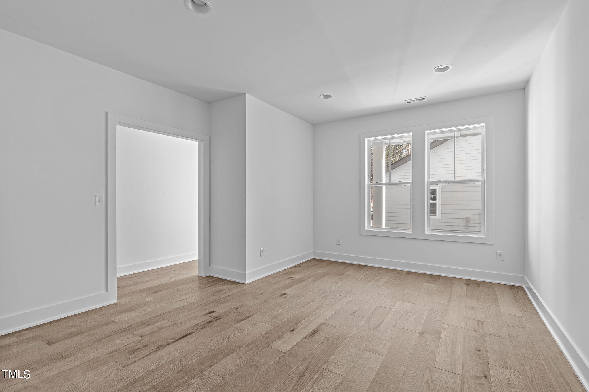 853 Athens Drive, Unit 101 Raleigh, NC 27606 - Photo 25 of 61 an empty room with wooden floor and windows