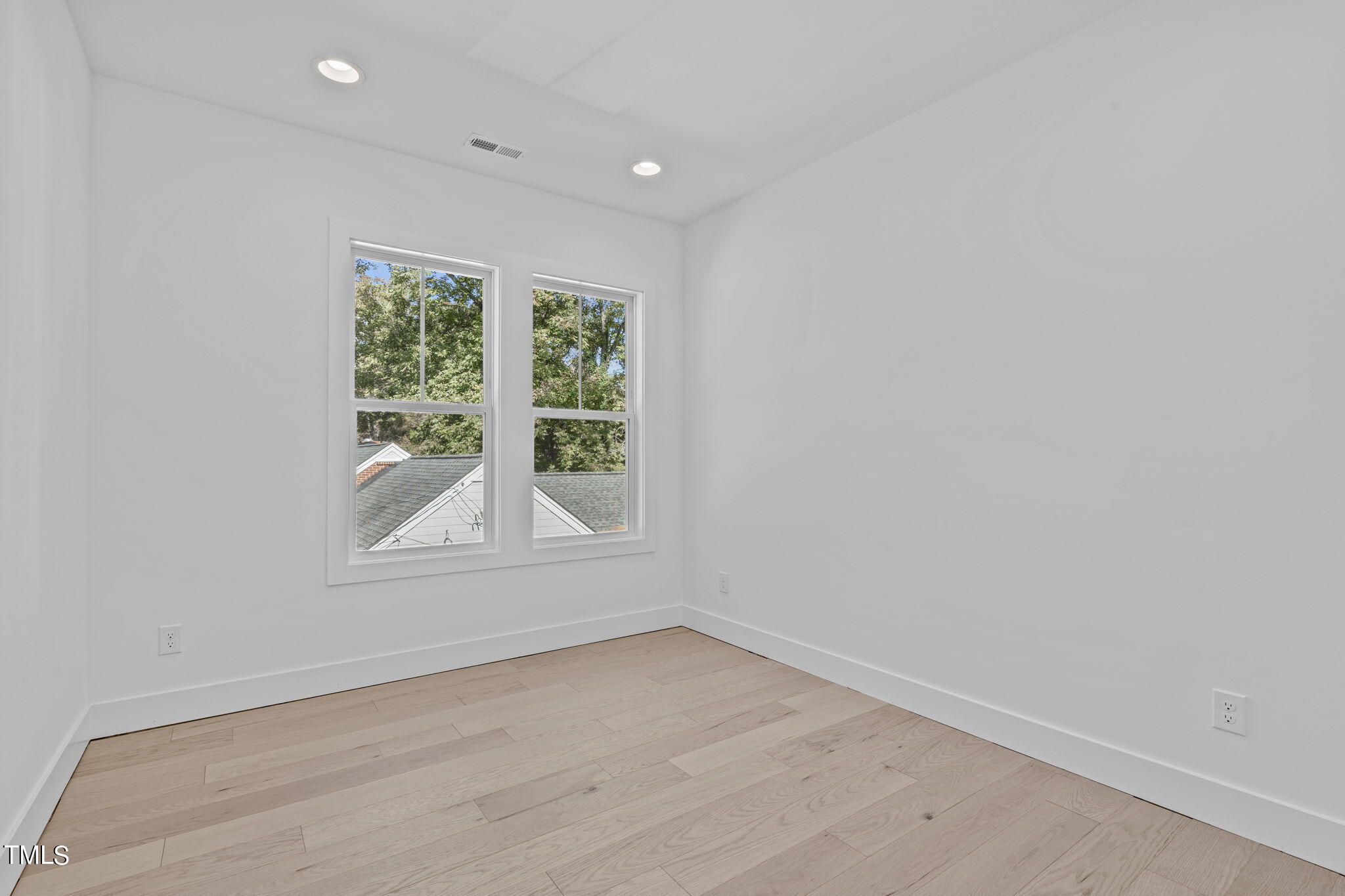 853 Athens Drive, Unit 101 Raleigh, NC 27606 - Photo 36 of 61 an empty room with wooden floor and windows