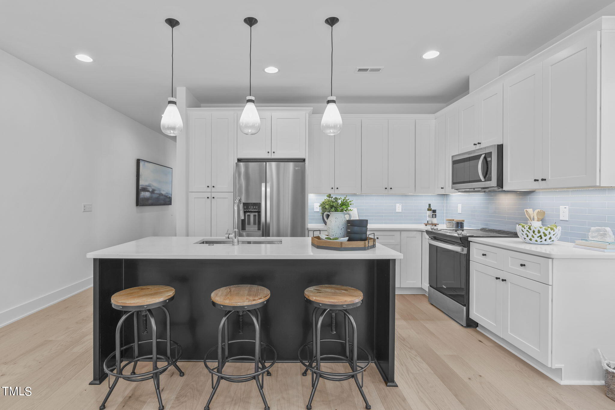 853 Athens Drive, Unit 101 Raleigh, NC 27606 - Photo 6 of 61 a kitchen with stainless steel appliances kitchen island a chandelier and refrigerator