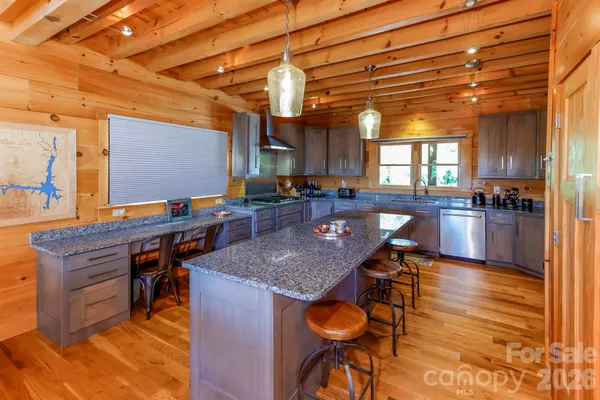 a kitchen with stainless steel appliances granite countertop a stove a sink dishwasher and cabinets with wooden floor