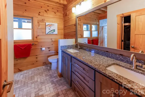 a bathroom with a granite countertop toilet sink and mirror