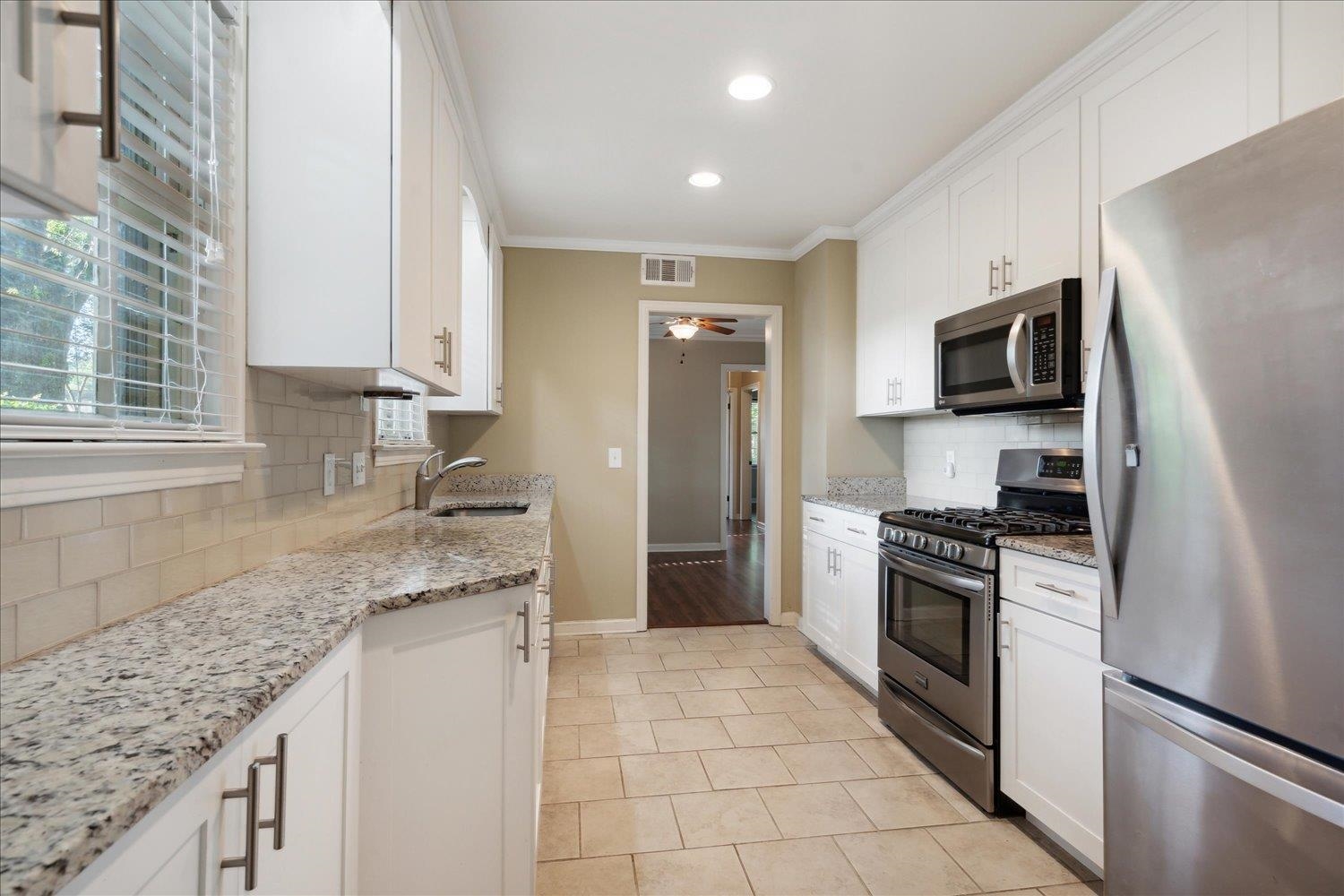964 Ivy Road Memphis, TN 38117 - Photo 14 of 33 a kitchen with granite countertop a sink stove and refrigerator