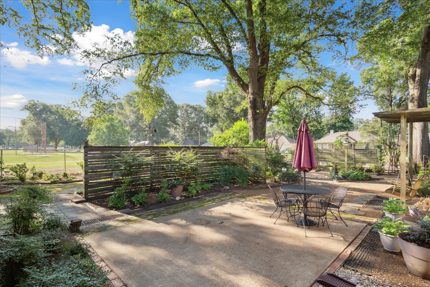 964 Ivy Road Memphis, TN 38117 - Photo 29 of 33 a backyard of a house with table and chairs under an umbrella