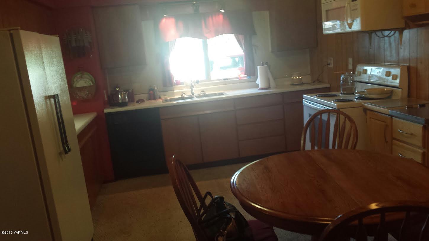 5490 Lateral A Road Wapato, WA 98951 - Photo 7 of 11 a view of a kitchen with a sink a window and wooden floor